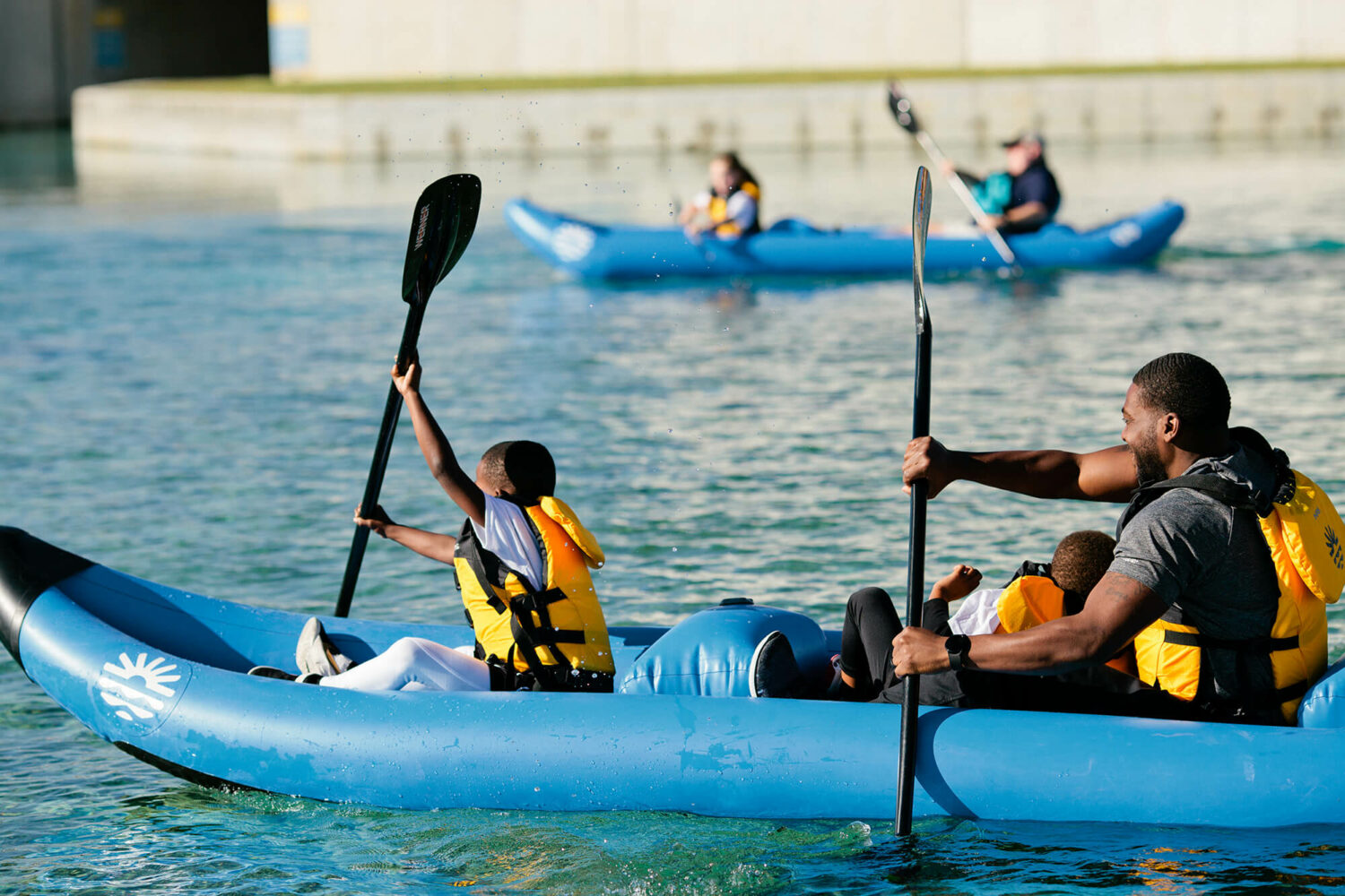 Father and son flatware kayaking and enjoying family time outside at Montgomery Whitewater Park in Montgomery, Alabama.